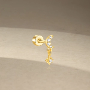 Macro shot of gold moon and star cartilage stud with cubic zirconia and flat back screw