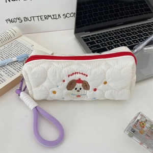 Close-up of quilted heart-pattern pencil case with cute dog embroidery and purple handle.