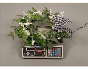 Close-up of artificial leaf wreath with white berries and bow, weighing 270g