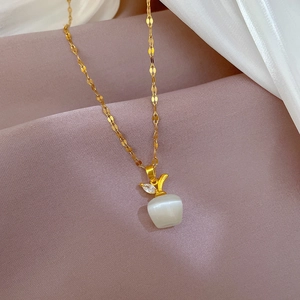 Detailed view of a gold-plated titanium necklace with cat eye stone apple pendant and leaves