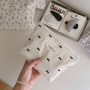 Handheld light gray floral cotton makeup bag with bow patterns and zipper closure