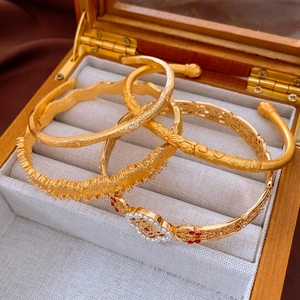 Detail of vintage hollow gold bracelets with pearls and matte finish in a jewelry box