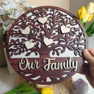 Close-up of wooden family tree ornament with five heart charms and Our Family text