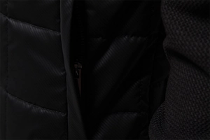 Detail of black quilted jacket featuring hidden zipper pocket and mesh fabric texture