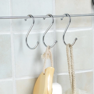 Polished silver stainless steel S-shaped hooks on a metal rod for kitchen and wardrobe