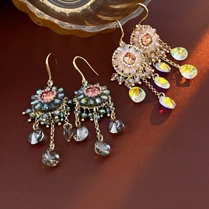 Vintage bohemian drop earrings with zircon crystals and layered metal tassels on brown leather