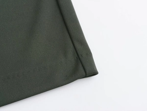 Detailed close-up of dark olive green pleated fabric texture and precise stitching detail