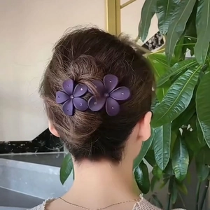 Detailed view of elegant purple acrylic flower hair clip with sparkling rhinestones
