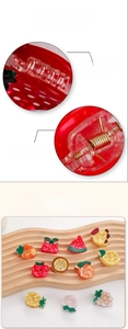 Detailed view of small fruit hair clips featuring smooth finish and strong metal springs