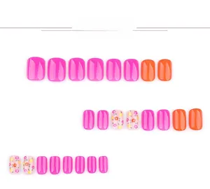 Detail view of pink and orange press-on nails with floral patterns in various sizes