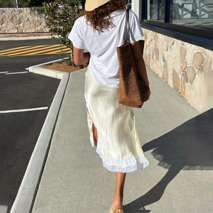 Eleganter beiger Satin-Midirock mit weißem Spitzenbesatz und Seitenschlitz für den Urlaub