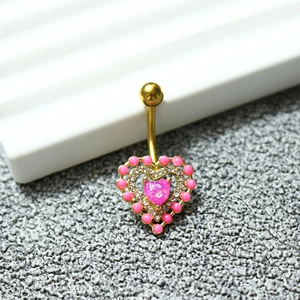 Gros plan détaillé d'un piercing de nombril en forme de cœur rose avec zircon et dorure