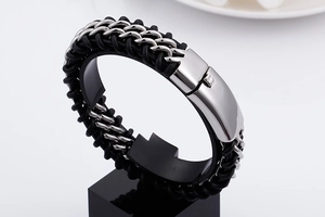 Macro shot of black braided leather bracelet with a silver stainless steel magnetic clasp