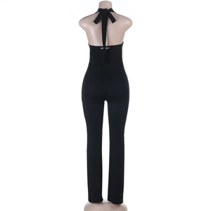 Detail of black halter jumpsuit showing backless design and white waist lettering print