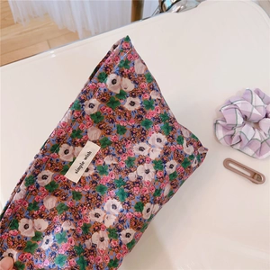 Close-up of vintage floral cosmetic bag with cotton fabric texture and simple wish logo
