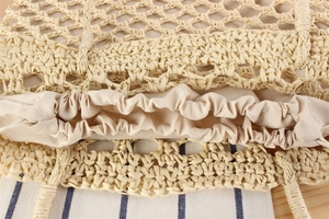 Detail shot of hand-woven straw bag featuring a secure drawstring closure and fabric lining