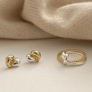 Close-up of 925 sterling silver knot earrings and ring set with bi-color finish