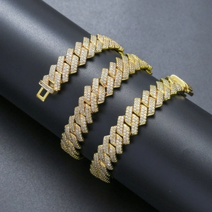 Close-up of three gold Cuban chains with pavé-set clear cubic zirconia on a dark stand