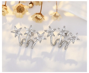 Detailed macro view of silver flower crawler earrings with micro-set cubic zirconia