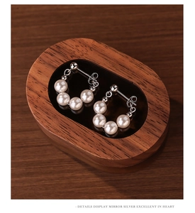Macro detail of S925 sterling silver beaded hoop earrings with four white pearls