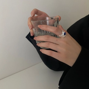 Irregular textured S925 silver ring with oval blue gemstone worn by a fashion model