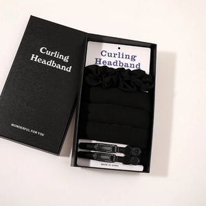Detail of black curling headband set including scrunchie and hair clips in a gift box