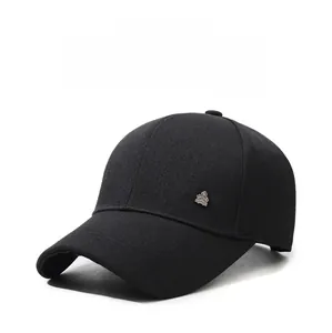 Dettaglio di un cappello da baseball nero con emblema metallico a corona dorata da uomo