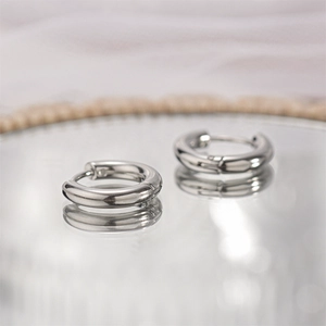 Macro shot of silver polished titanium steel hoop earrings with reflective mirror finish