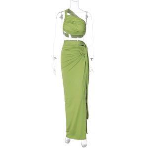 Detail of green two-piece set featuring a one-shoulder pleated top and side-tie slit skirt