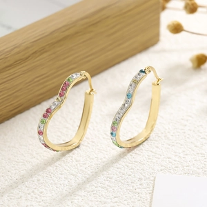 Luxurious gold heart hoop earrings with multi-colored crystals on a natural background