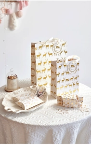 Detail of Christmas gift box set with gold reindeer foil and holiday hang tags