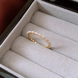 Detalle del anillo chapado en oro de 14K con perlas y circonitas en caja de terciopelo gris