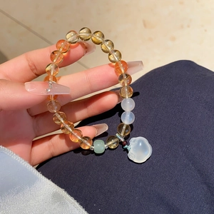 Detailed shot of yellow crystal beaded bracelet featuring a white jade rabbit charm