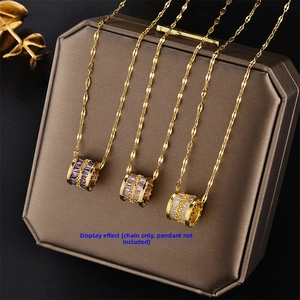 Macro shot of gold-plated cylinder pendants with purple and pink square crystals