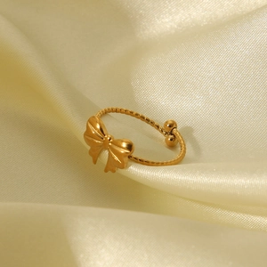 Detailed close-up of golden butterfly open ring on elegant white silk background