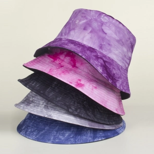 Stack of tie-dye bucket hats in various colors showing fabric texture and stitching details