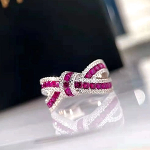 Elegant silver bow ring featuring red gemstones and sparkling pavé crystals