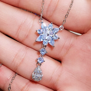 Set collana in argento con fiori e gocce di zirconi scintillanti mostrato in primo piano