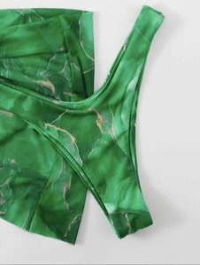 Detail of green marble print bikini bottoms with gold accents and ribbed texture fabric