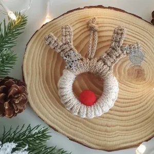 Close-up of a handmade crochet reindeer Christmas ornament on a rustic wooden background