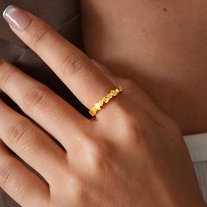 Close-up of continuous 24k gold-plated heart-shaped ring on model hand