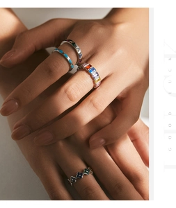 Close-up of four s925 silver rings with colorful gemstones and clover design on model