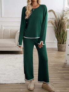 Detail of green knitted lounge set featuring white contrast trim and side slit hems