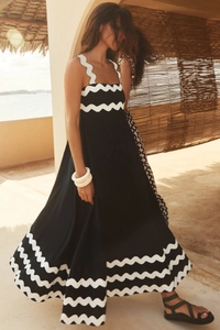 Detail of elegant black long dress with white scalloped trim and cotton-linen texture