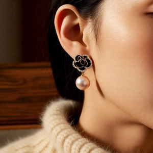 Detailansicht der Kamelien-Perlenohrringe mit schwarzer Emaille und Diamanten am Model
