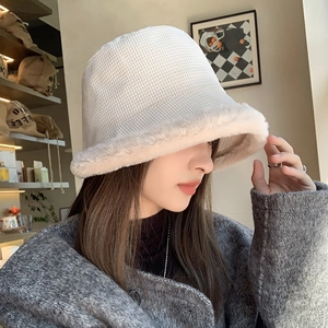Detail of off-white knitted waffle texture and plush faux fur brim on winter bucket hat