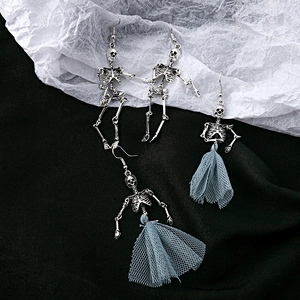 Macro shot of punk skeleton earrings with blue mesh skirt on black and white texture