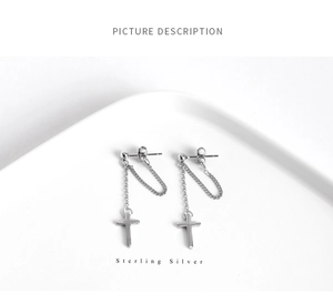 Detail view of sterling silver cross chain earrings with minimalist punk style design