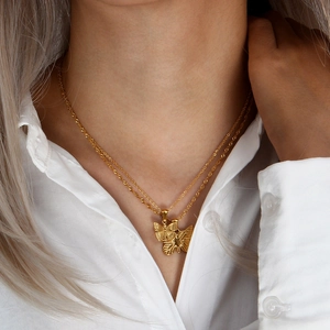 Gold double-layered stainless steel necklace featuring elegant butterfly pendants on model