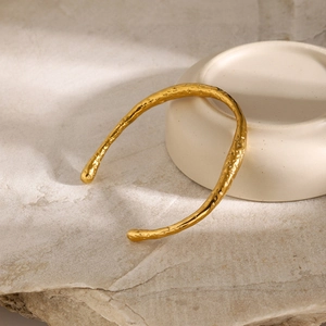 Detailansicht der gehämmerten Textur des 18k vergoldeten Edelstahl Armreifs in Gold